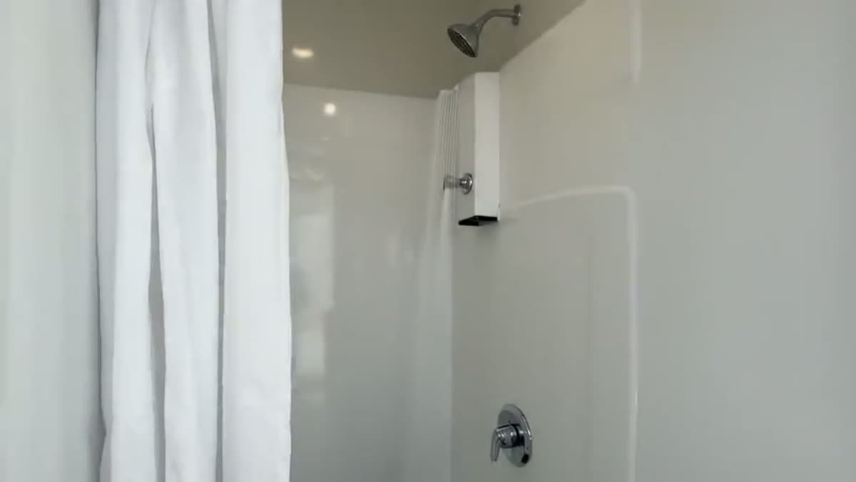 Interior of a Utah shower trailer with a finished vanity, mirror and private shower stall